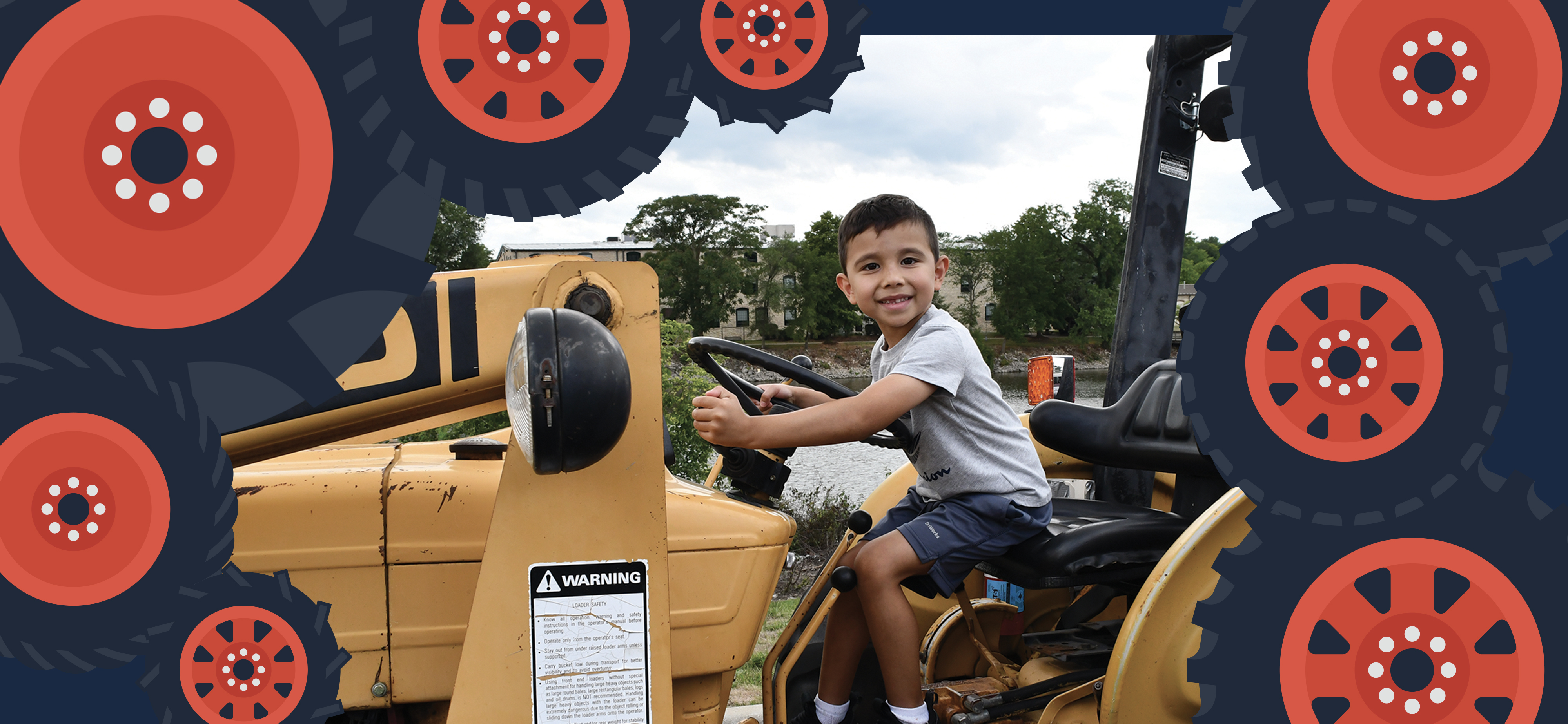 Little boy smiling while sitting on a tractor during a touch a truck event