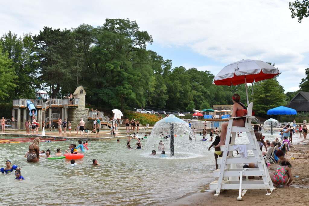 A lifeguard watches patrons enjoy the shallow water at Hall Quarry Beach