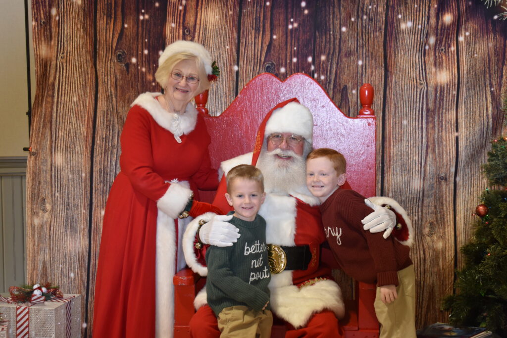 Two children posed with Santa and Mrs. Calus.