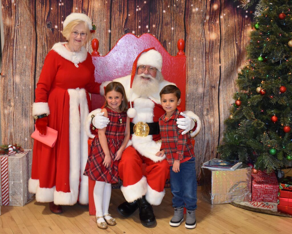 A family posed with Santa and Mrs. Claus.