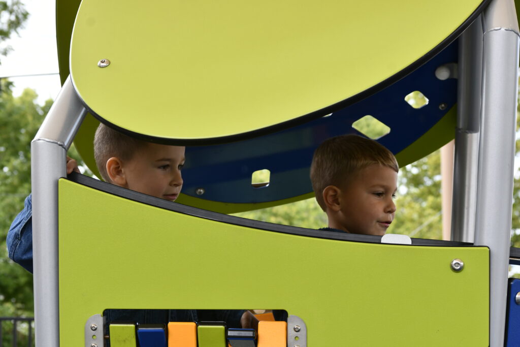 Two young boys in play structure looking out