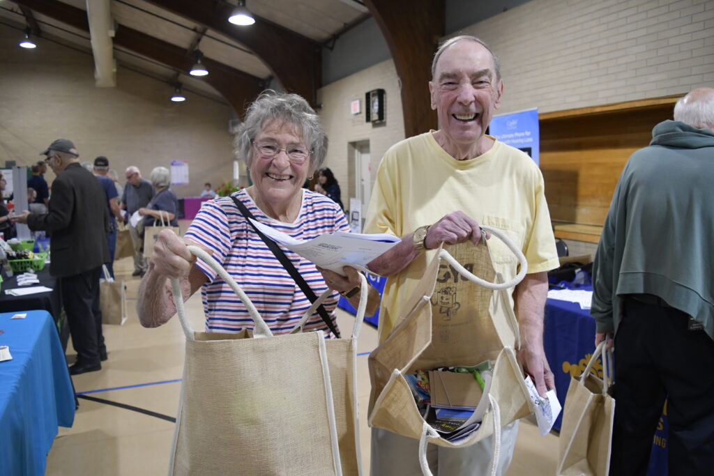 Super Savvy Senior Expo attendees showing free bags.