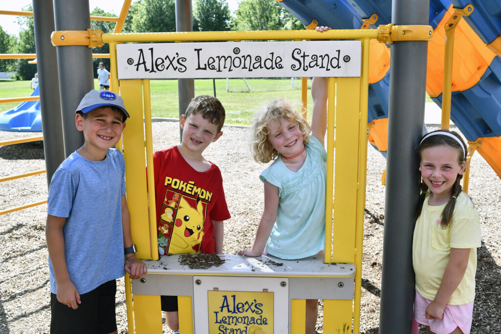 Four campers pose on the playground during summer camp