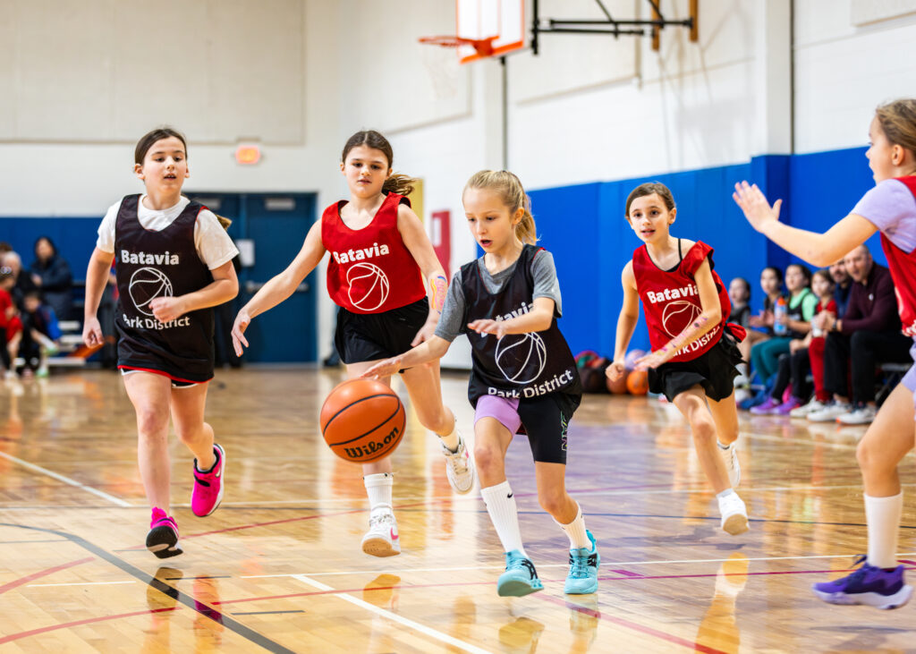 Girls focus on the ball during a basketball league game.