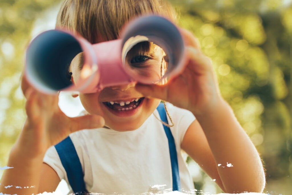 Child looking through a set of paper tube binoculors