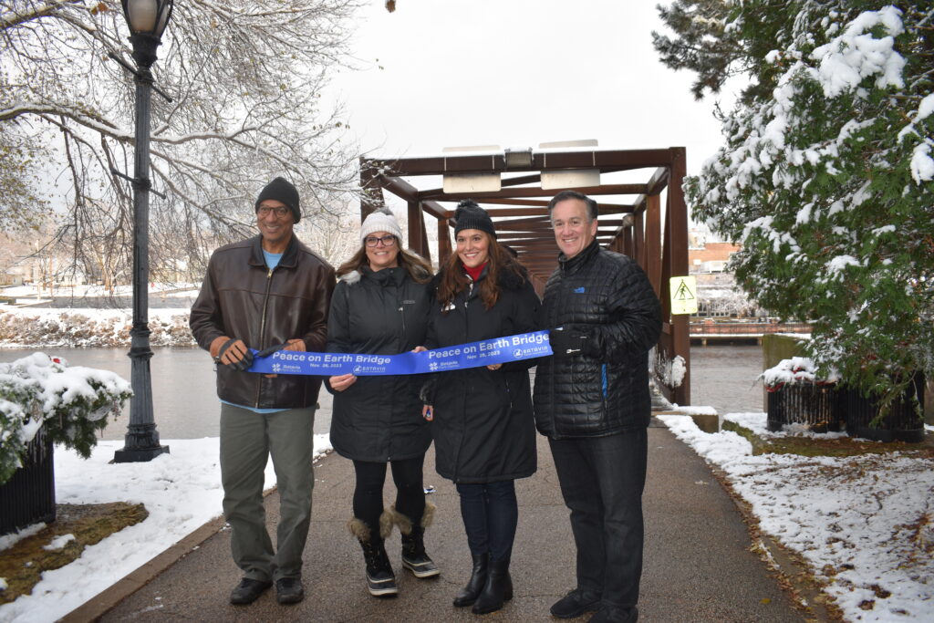 Batavia Park District Board Members holding a grand opening ribbon for the Peace Bridge.