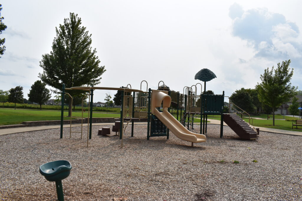 Bennett Park playground displaying monkey bars, slides, climbing structure and spinning chair.