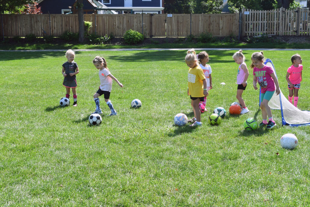 Young soccer players practice kicking the ball during All Star Sports soccer