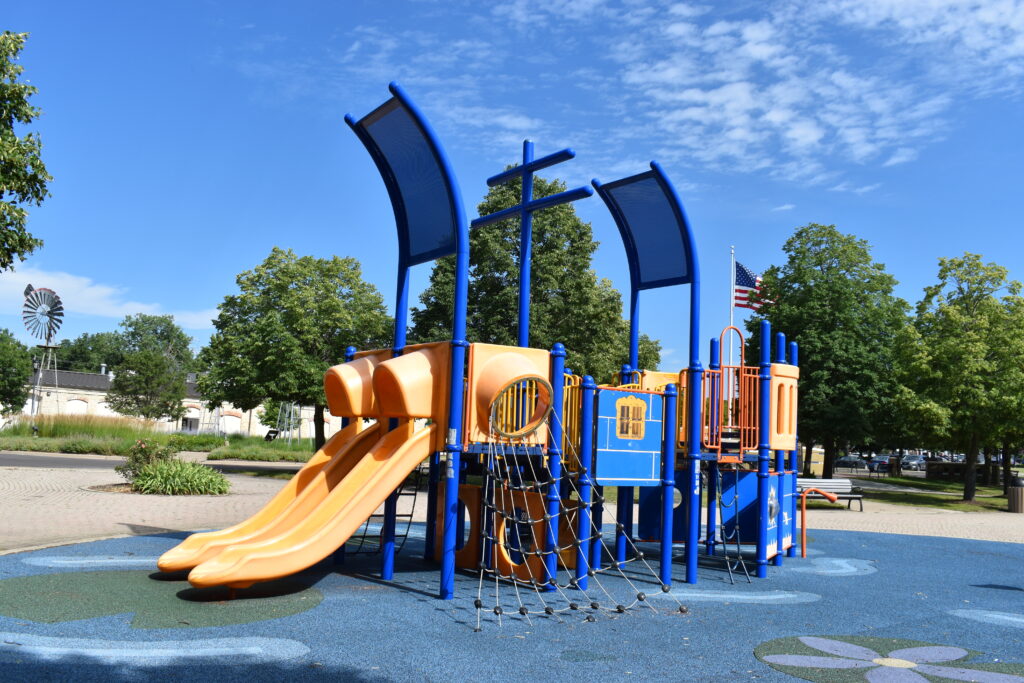 Batavia Riverwalk boat playground showing two slides and interactive play equipment.