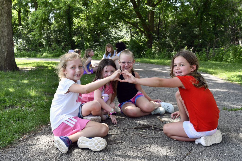 A group of girl campers pose for a photo outside