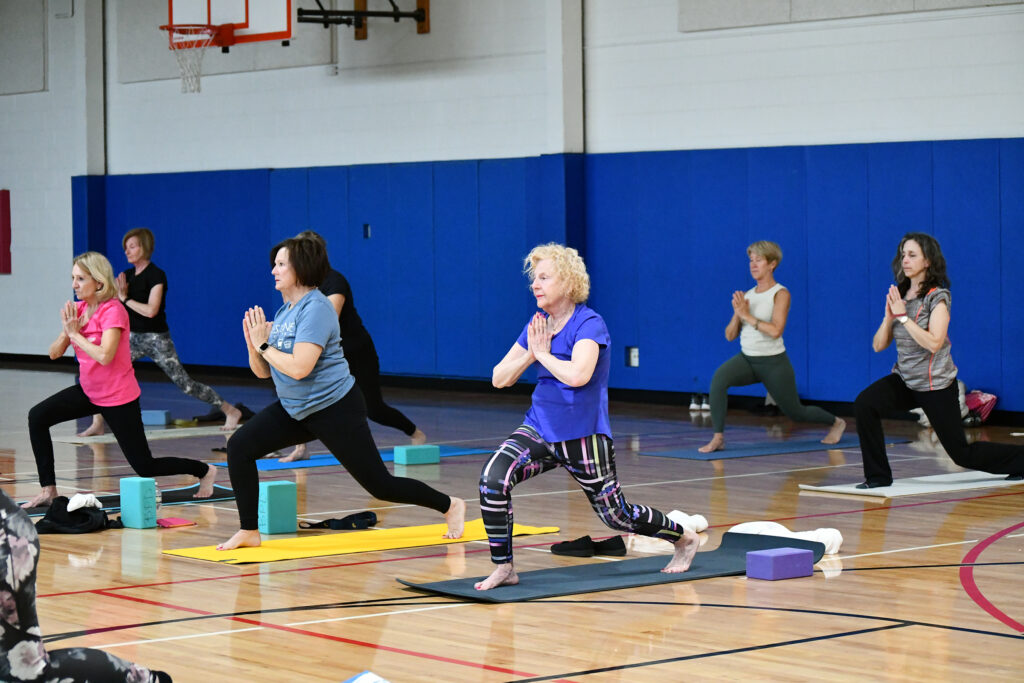 Adults in lunge pose during yoga class