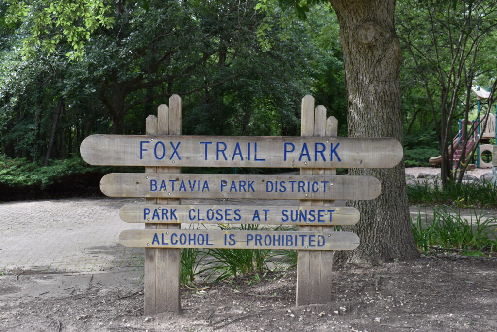 Fox Trail Park sign that says the park name and hours.