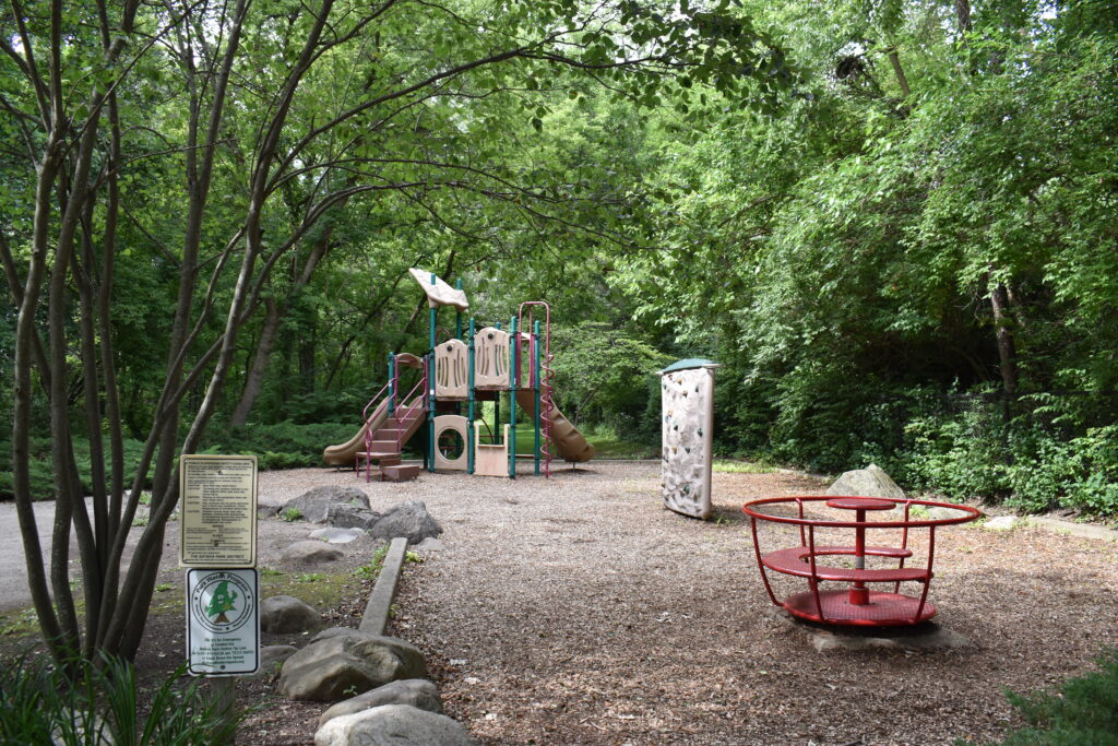 Fox Trail Park playground showing a spinning and climbing structure along with a slide.