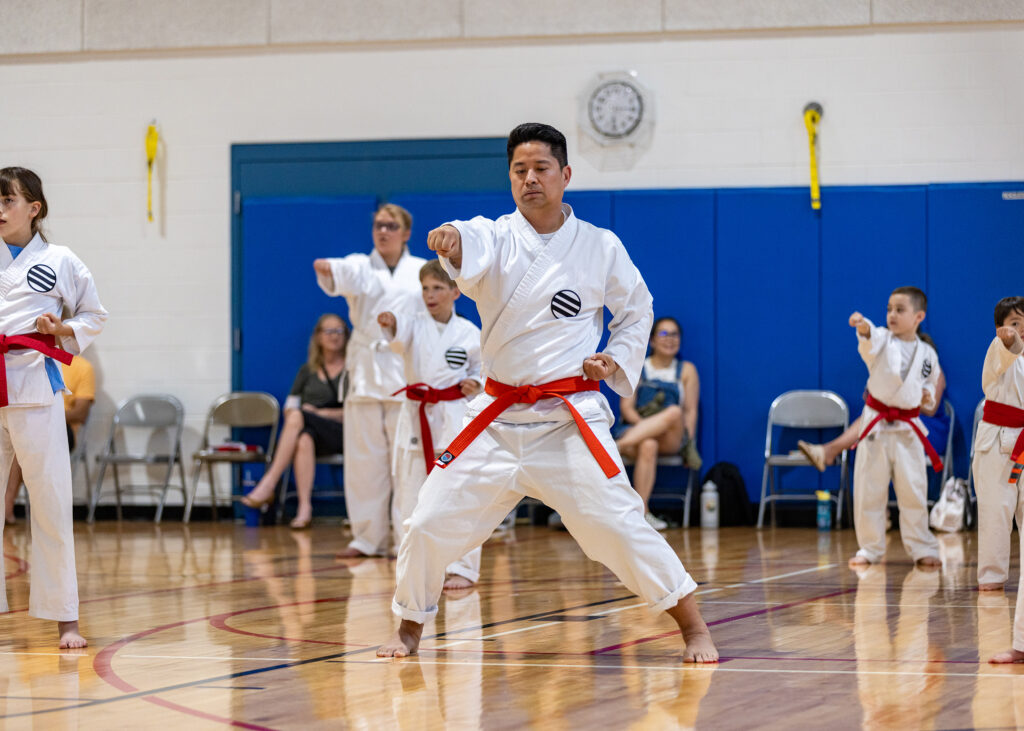 A karate instructor leads a class in the gym