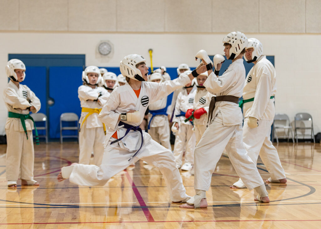 Karate students learn to spar wearing protective gear