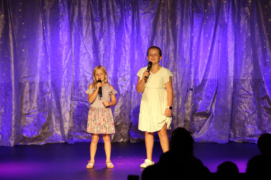 Two girls singing on stage