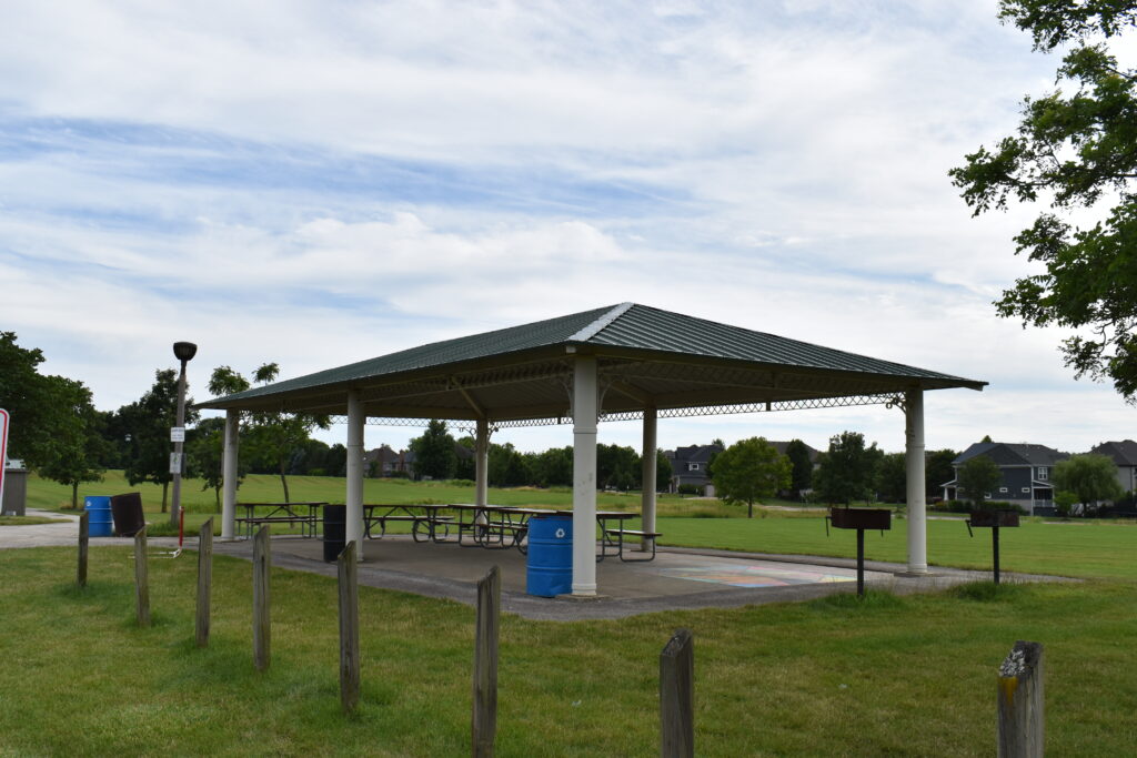 Prairie Path Park rentable pavilion showing picnic tables, community grills, and garbage cans.