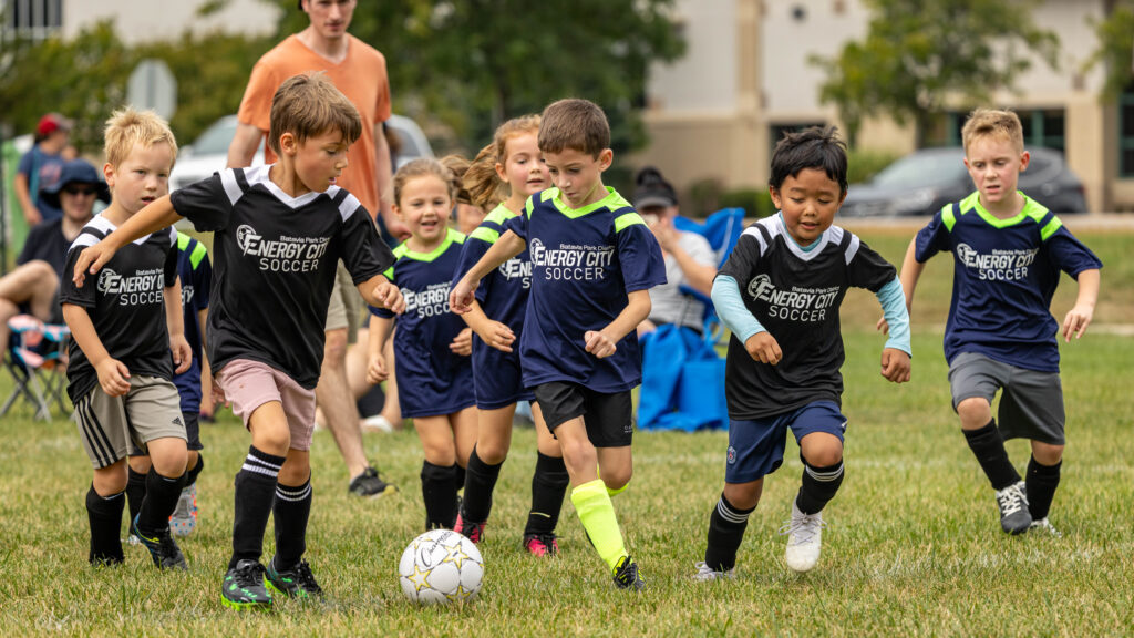 Young soccer players try to gain control of the ball during a soccer league game