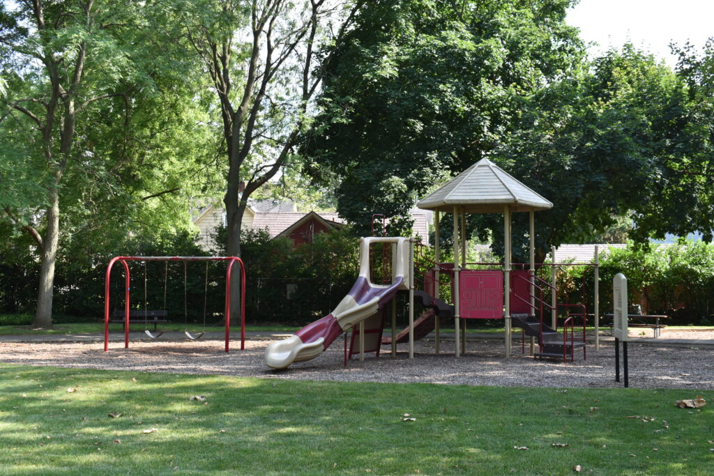 Walnut Park playground showing a playset with a small side and swings.
