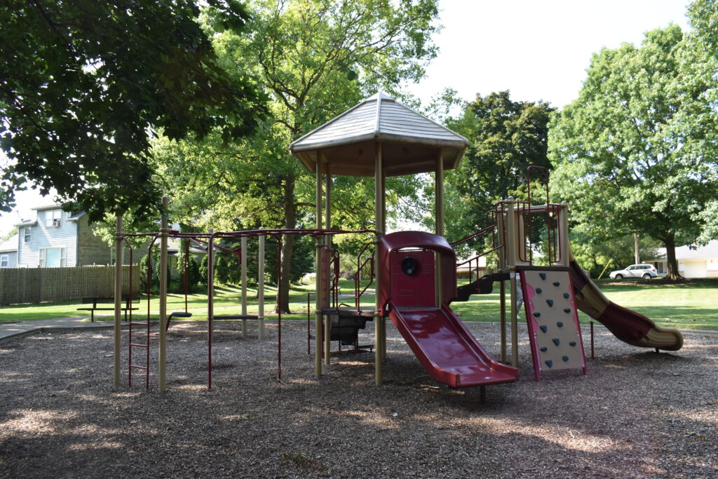 Walnut Park showing monkey bars, small slide and a rock climbing structure.