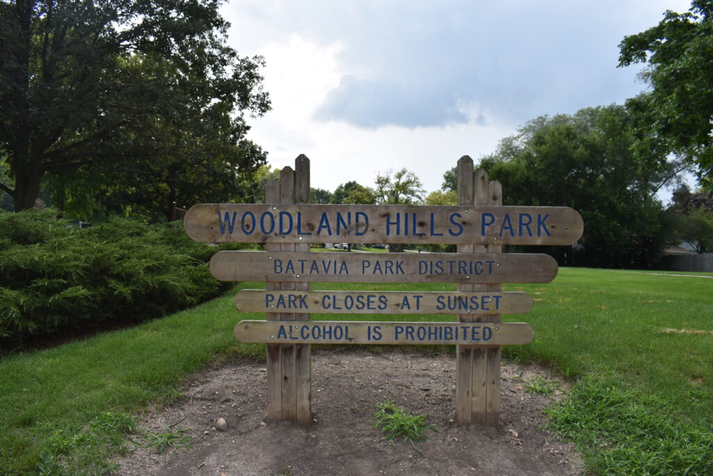 Woodland Hills Park sign that says the park sign with hours.