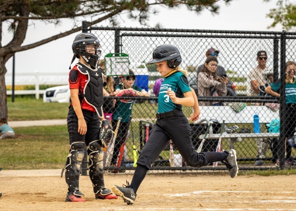 Softball player runs to home plate during a game