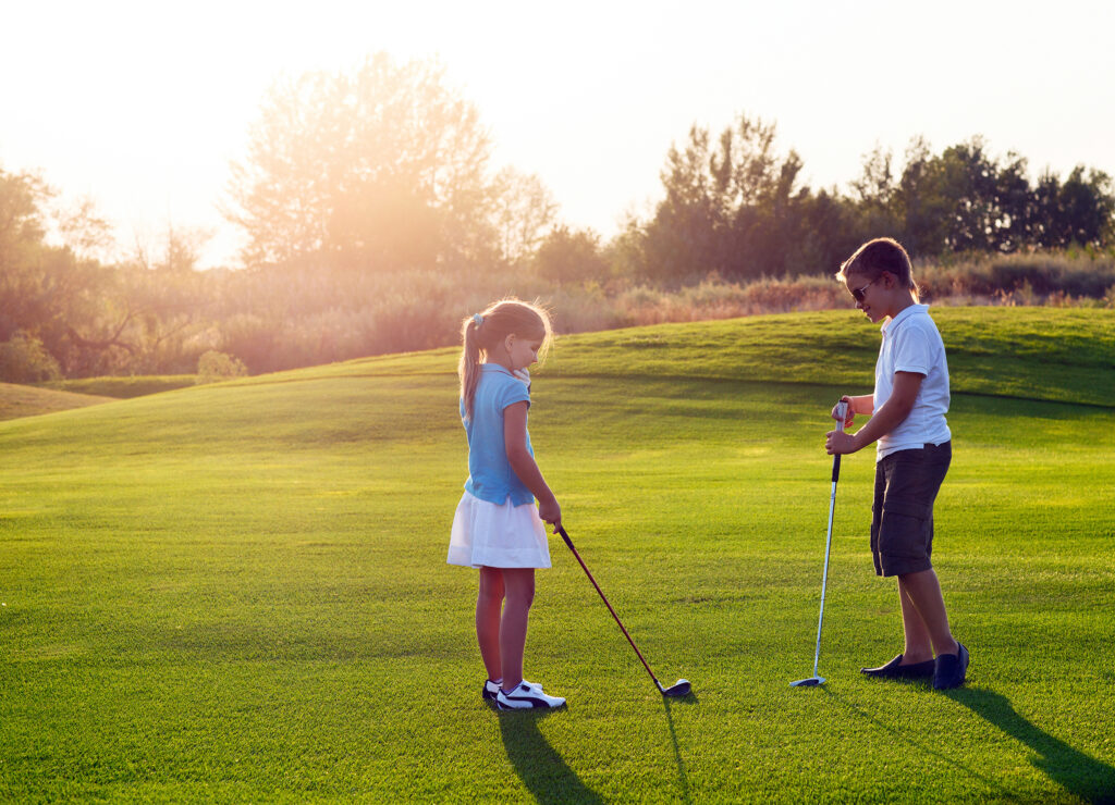 Kids golfing at sunset