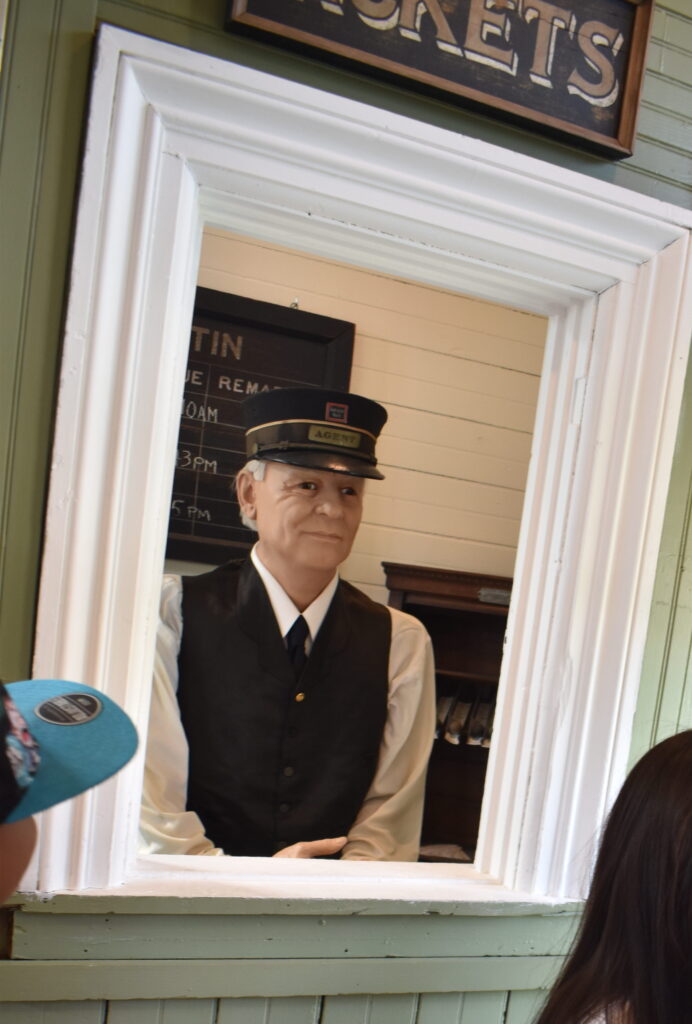 Children with train conductor model in museum