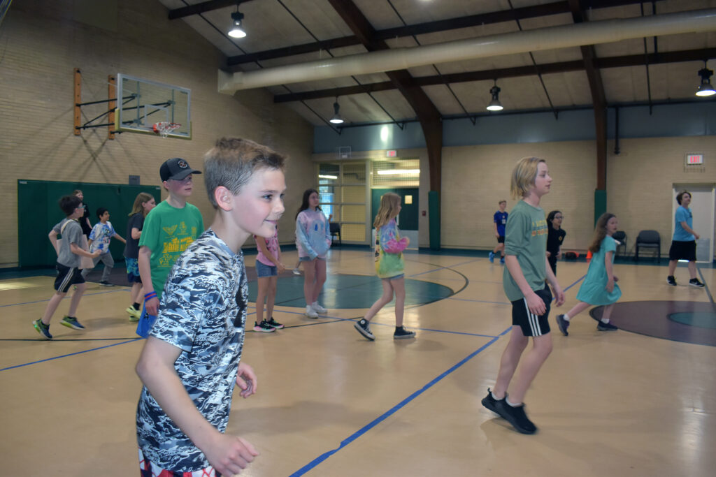 Middle school students are poised to get the ball on the basketball court during middle school open gym