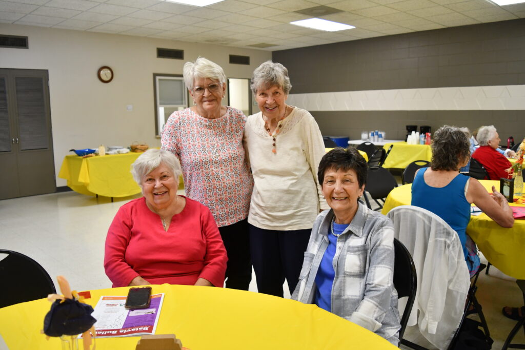 Four senior ladies pose for a photo at the monthly senior lunch